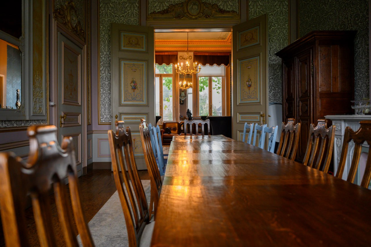 Historische eetzaal met lange houten tafel en kroonluchter